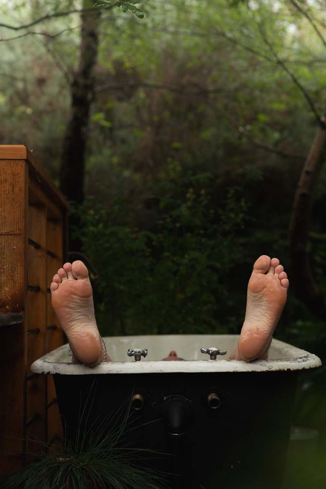 A persons feet who is having a cold water bath