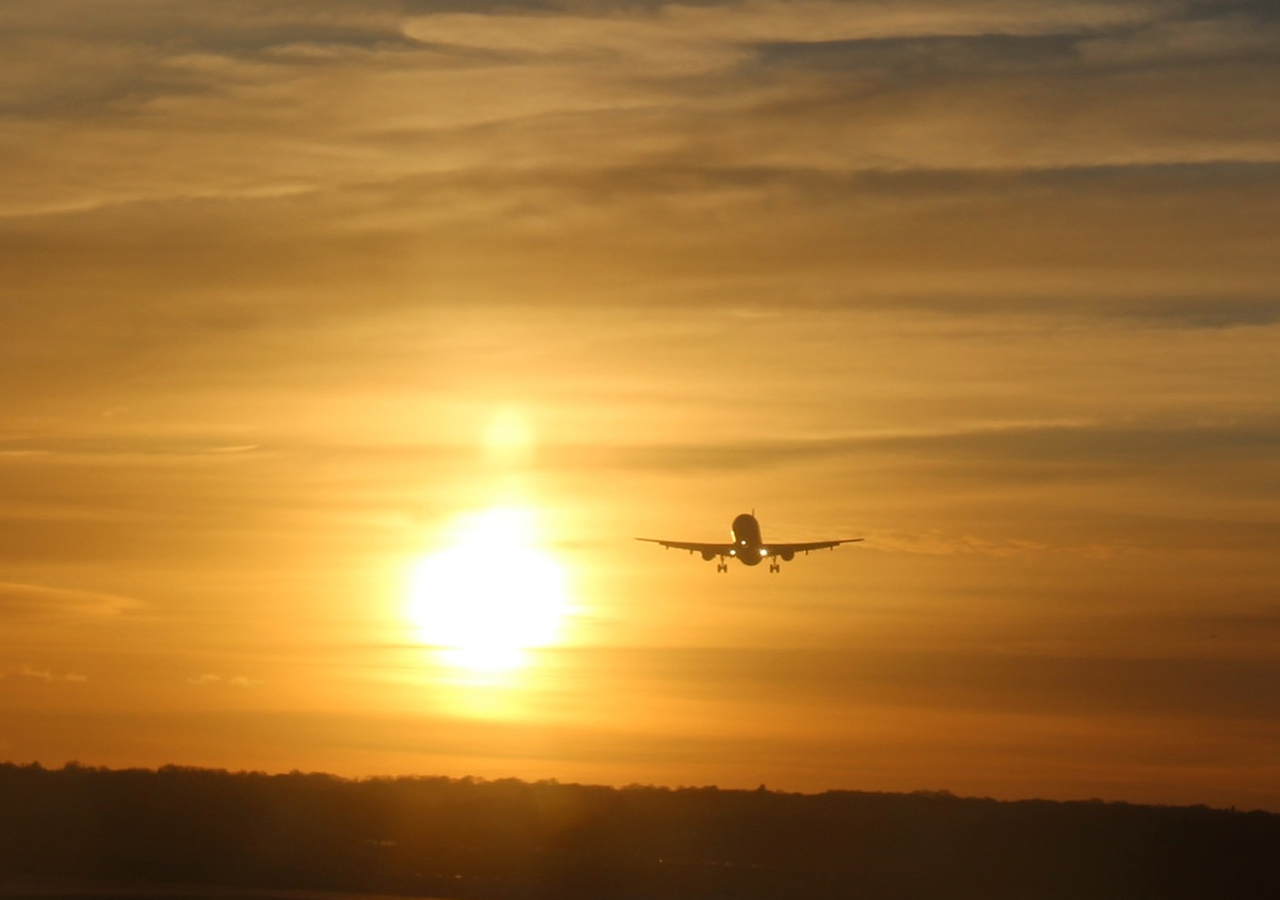 An aeroplane coming into landing at sunset