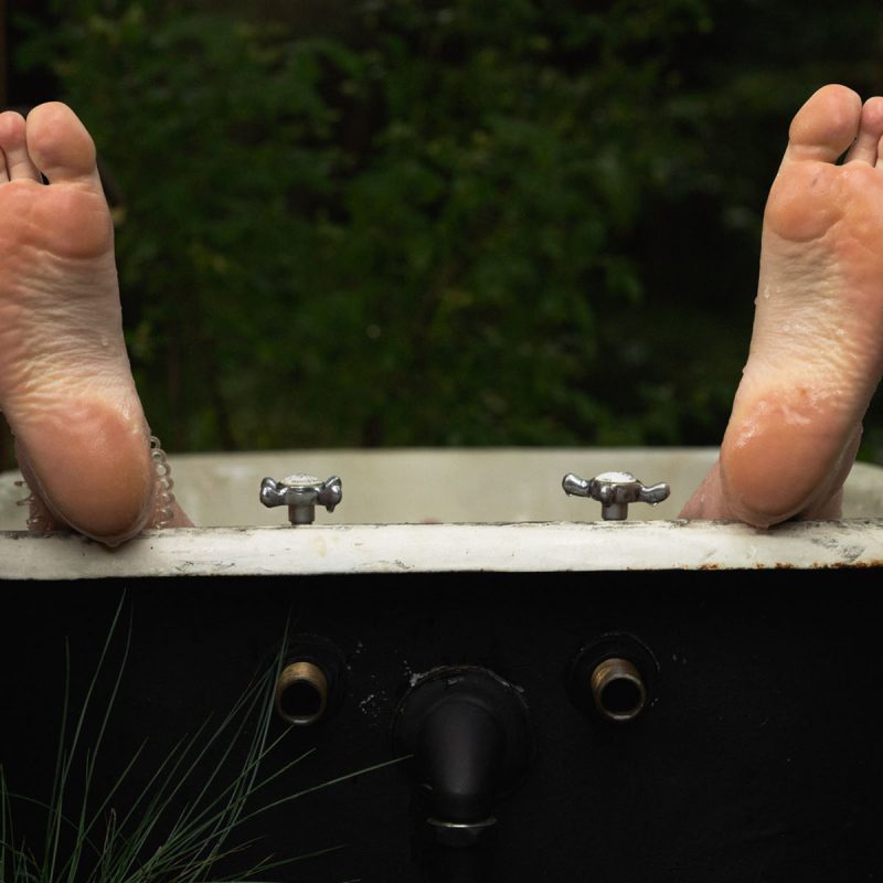 A persons feet who is having a cold water bath