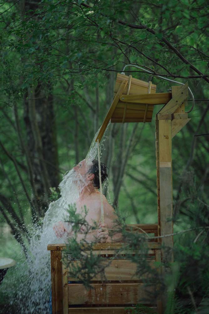 A person under cold water being spilled from a bucket during cold water therapy