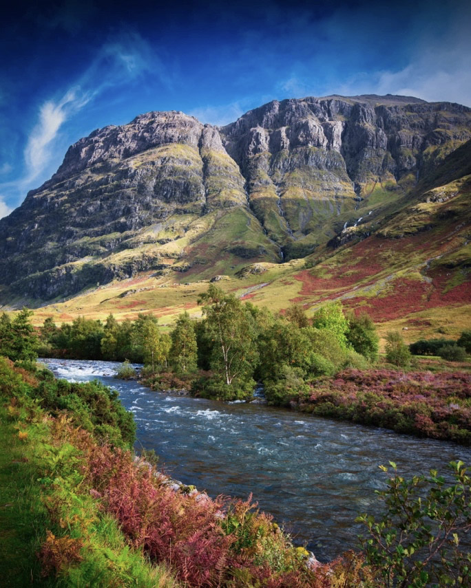 Imposing and striking mountains with river in foreground in Glencoe, Scotland