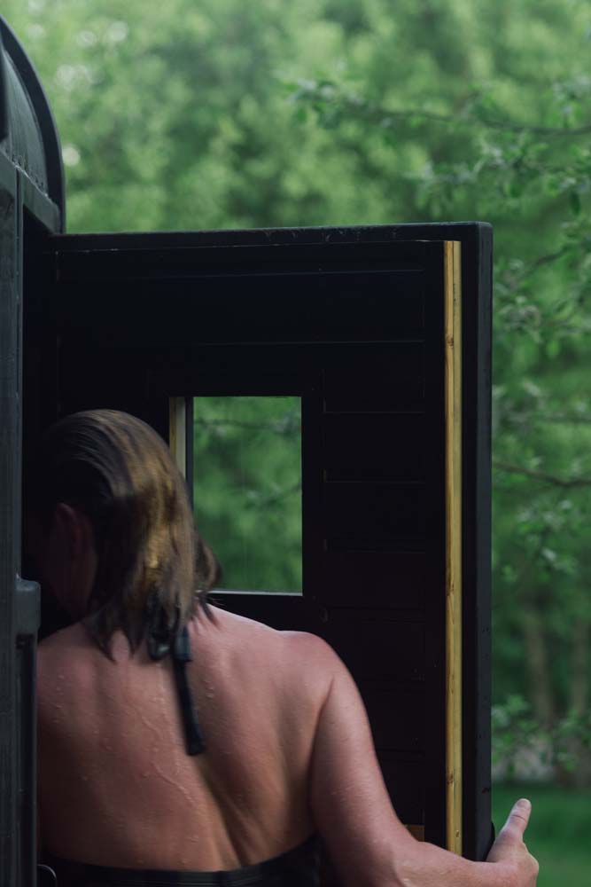 A person entering a sauna at Nowhere Sauna for hot cold water therapy