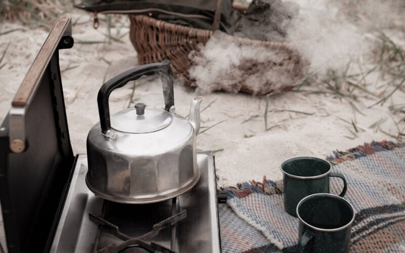 A kettle on a stove on a beach