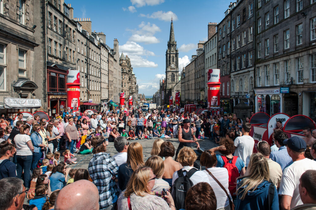 People at the Edinburgh Fringe Festival watching street performers.